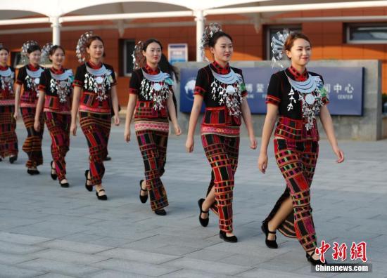 4月8日，身著黎族服飾引導員走過博鰲論壇新聞中心。博鰲亞洲論壇2018年年會在海南博鰲舉行。<a target=&apos;_blank&apos; href=&apos;http://www.chinanews.com/&apos;><p class=